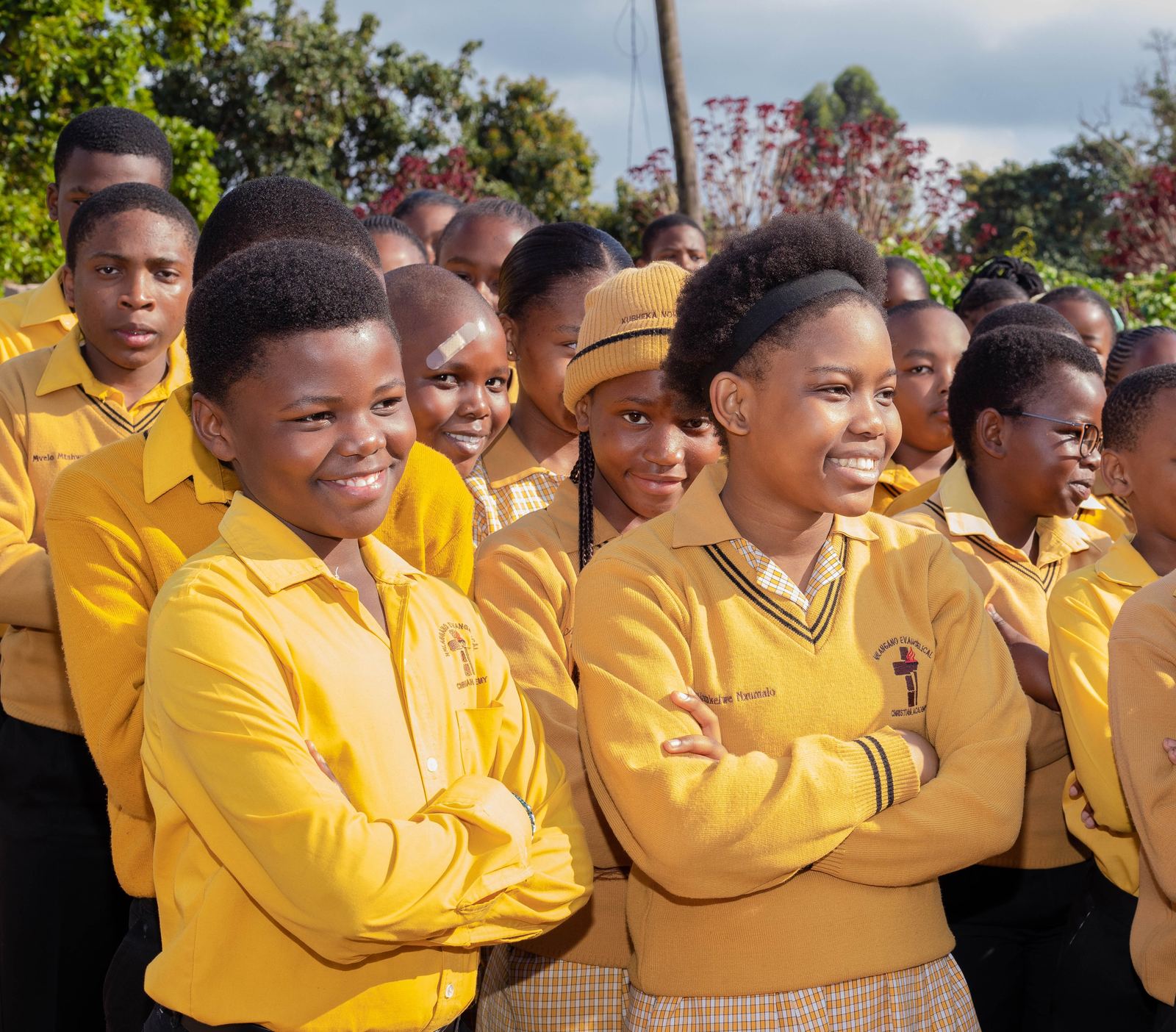 NECA pupils in their school uniform gathered together outdoors